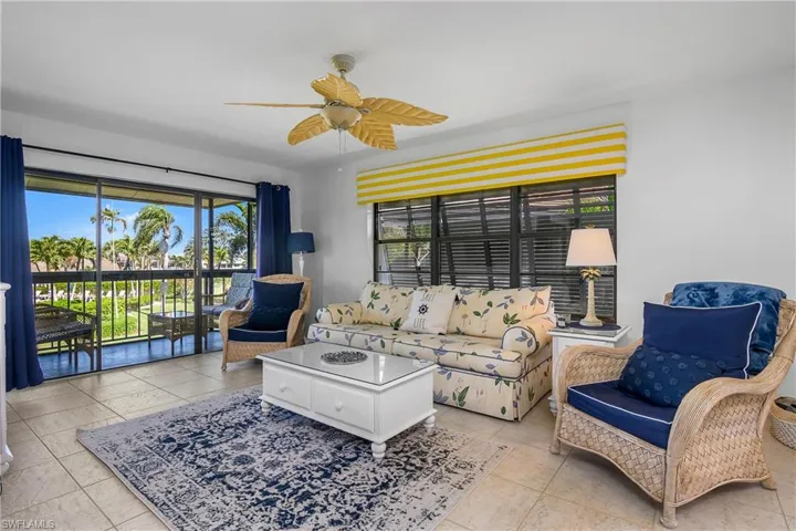 Tiled living room with ceiling fan. Notice the decorative shutters outside the window.