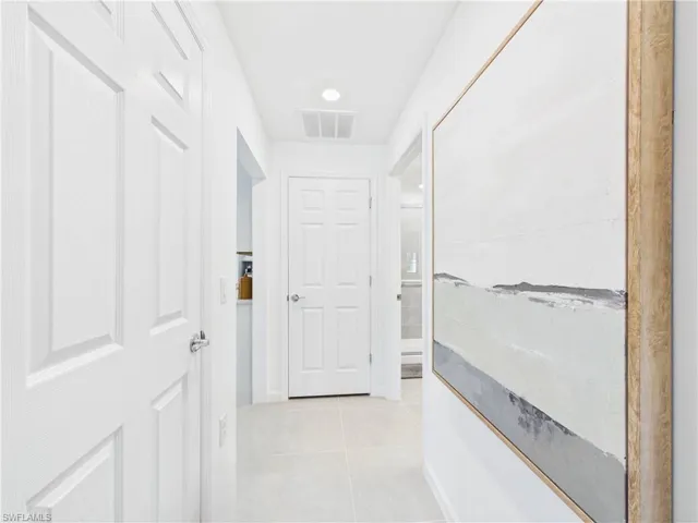Corridor with light tile patterned floors and recessed lighting