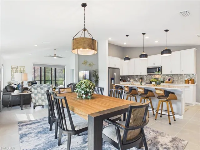 Dining space featuring ceiling fan, vaulted ceiling, light tile patterned floors, and recessed lighting