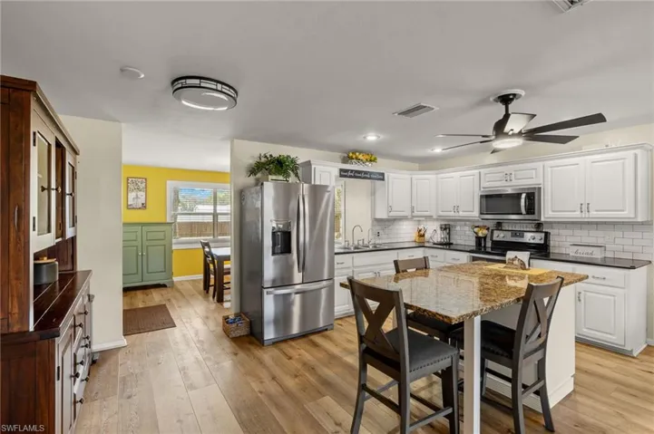 Kitchen featuring white cabinetry, appliances with stainless steel finishes, light hardwood / wood-style floors, and sink