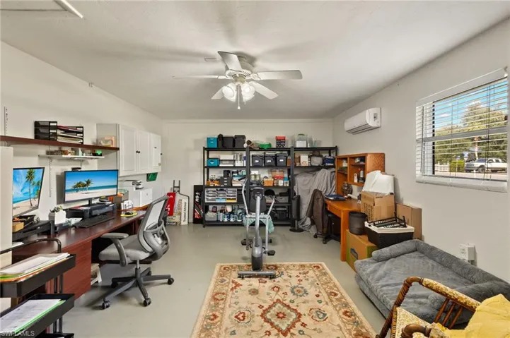 Office with an AC wall unit and ceiling fan