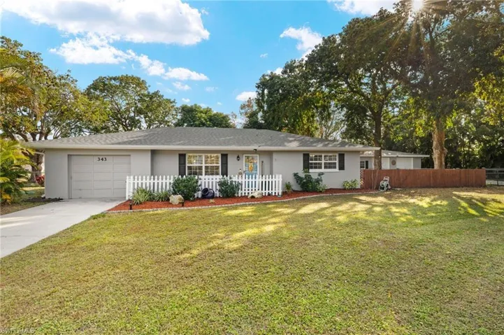 Single story home featuring a garage and a front lawn