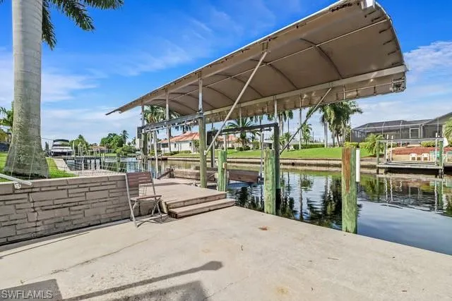 Dock area featuring boat lift, a water view, and a residential view