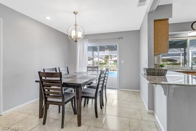 Dining room with suspended lighting and light tile patterned floors