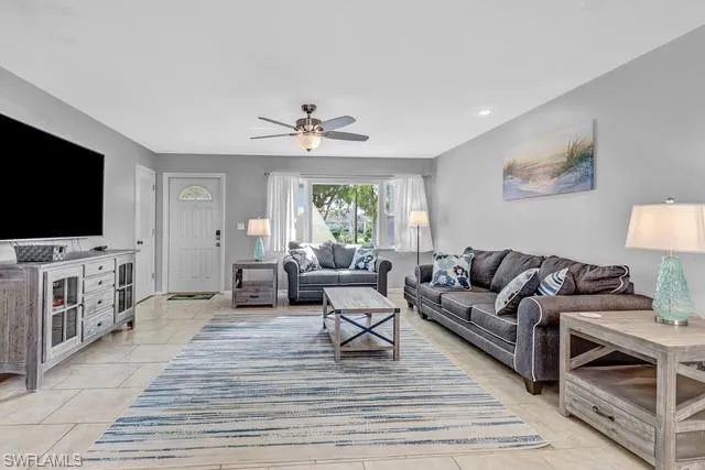 Living area featuring a ceiling fan and light tile patterned floors