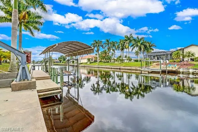 Dock with boat lift, a water view, and a residential view
