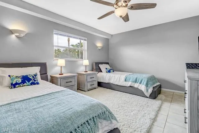 Bedroom with ceiling fan and light tile patterned floors