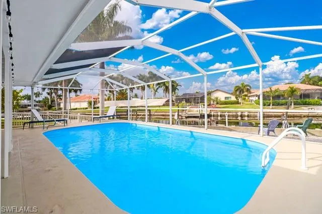 Swimming pool featuring a patio, a lanai, a sunroom, and a residential view