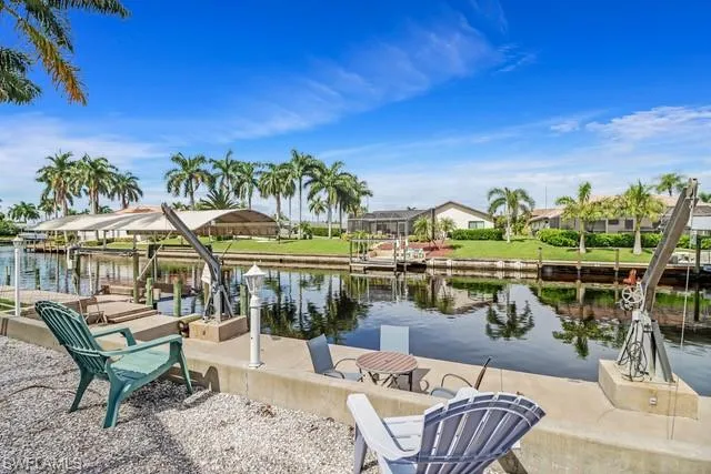 Dock area featuring a water view, boat lift, and a residential view
