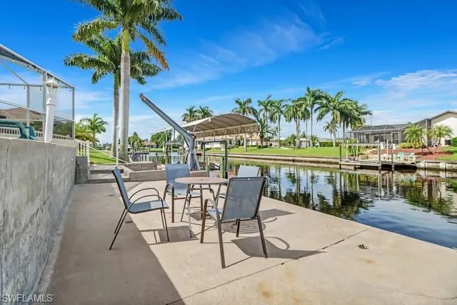 View of patio / terrace with a dock, boat lift, a water view, and a residential view