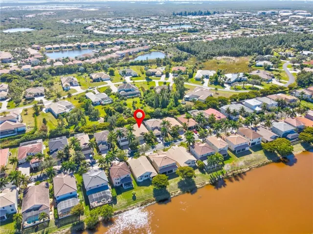 Aerial view of property and surrounding area with a large body of water and nearby suburban area