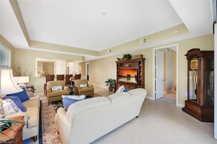 Living area featuring a tray ceiling, tile flooring, and a built-in media center