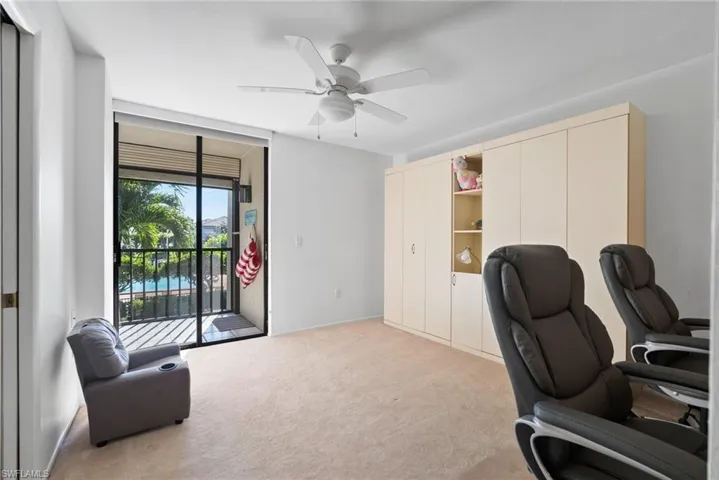 Carpeted home office featuring ceiling fan