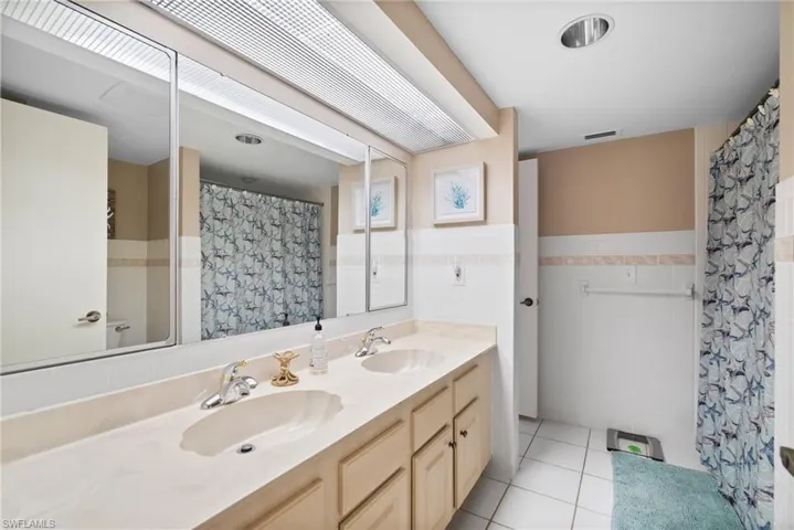 Bathroom with tile walls, tile patterned flooring, vanity, and a shower with curtain