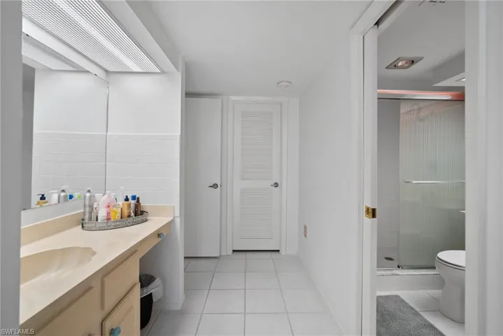 Bathroom with tile patterned flooring, vanity, toilet, and an enclosed shower