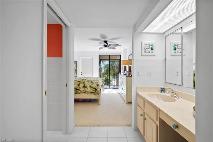 Bathroom with tile patterned floors, ceiling fan, and vanity