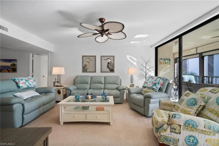 Living room featuring ceiling fan and light colored carpet