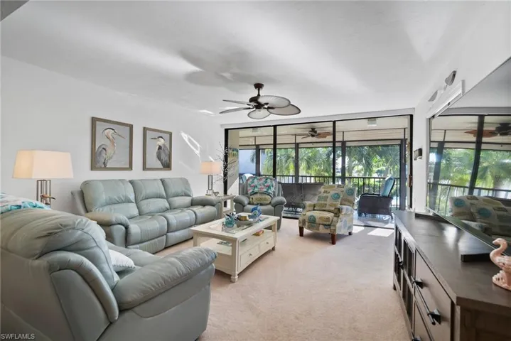 Carpeted living room featuring ceiling fan
