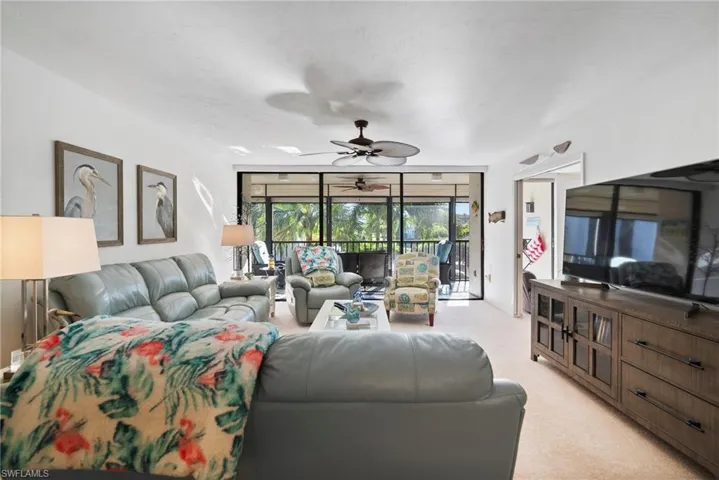 Carpeted living room with ceiling fan