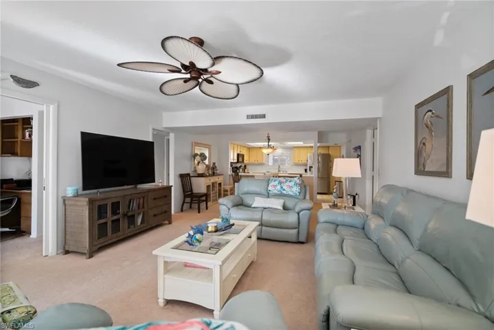 Living room with sink, ceiling fan, and light colored carpet