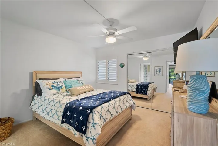 Carpeted bedroom with a closet and ceiling fan