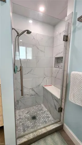 OWNER'S SUITE SHOWER W/NICHE AND BUILT-IN BENCH.  FRAMELESS GLASS DOOR.