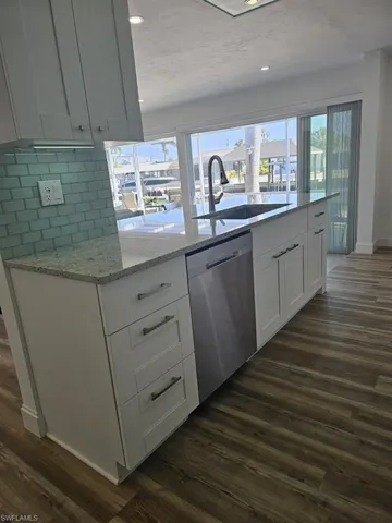 BIG KITCHEN WORK ISLAND.  FULL-HEIGHT TILED BACKSPLASH.  DOUBLE DIVIDE STAINLESS STEEL SINK W/HIGH ARC FAUCET.  UNDER-CABINET LIGHTING.  SOFT CLOSE DRAWERS AND CABINETS.