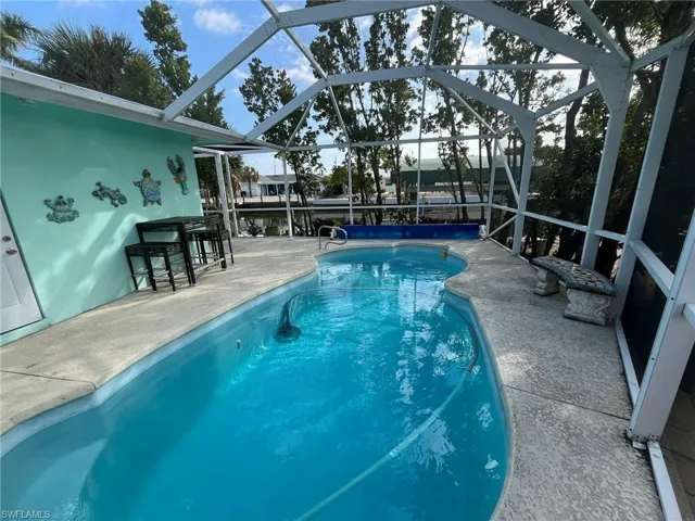 POOL VIEW TOWARDS CANAL.  DOOR TO LEFT LEADS TO GARAGE.