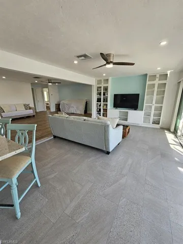 VIEW OF OPEN LIVING AREA.  BUILT-IN SHELVING (WITH DOORS).  RECESSED LIGHTING.  MODERN CEILING FAN W/LIGHT.  TILE FLOORING.