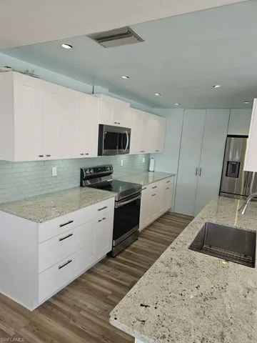 KITCHEN HAS GRANITE COUNTERTOPS.  FULL-HEIGHT TILED BACKSPLASH.  SOFT CLOSE CABINETS AND DRAWERS.  BIG PANTRY IS SHOWN AT MIDDLE REAR OF PHOTOS.  DOUBLE DIVIDE STAINLESS STEEL SINK W/HIGH ARC FAUCET.  PLANK VINYL FLOORING.  UNDER-CABINET LIGHTING.  RECESS LIGHTING. SAMSUNG STAINLESS STEEL APPLIANCES.