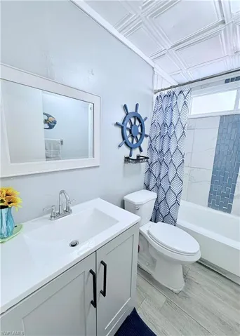 Bathroom with shower / bathtub combination with curtain and vanity
