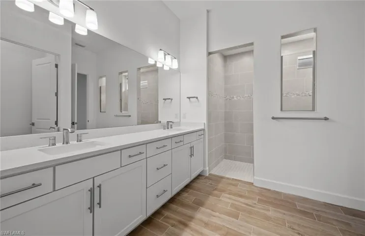 Bathroom featuring vanity and tiled shower