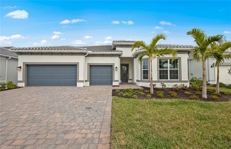 Mediterranean / spanish house featuring a garage and a front lawn