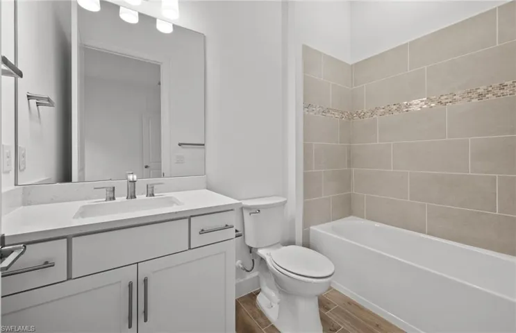 Full bathroom featuring vanity, toilet, and tiled shower / bath combo