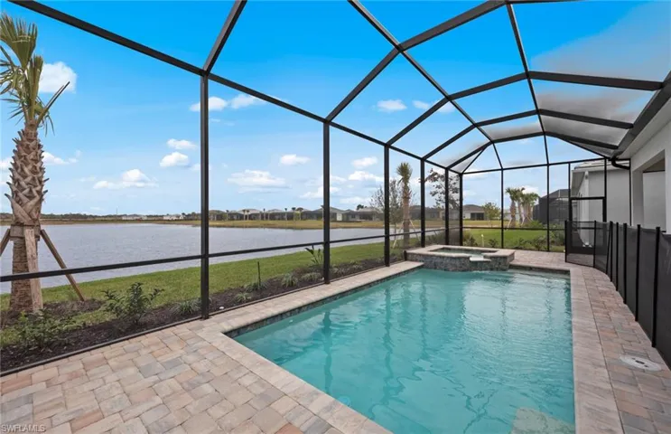 View of swimming pool featuring a patio area, an in ground hot tub, a water view, and glass enclosure