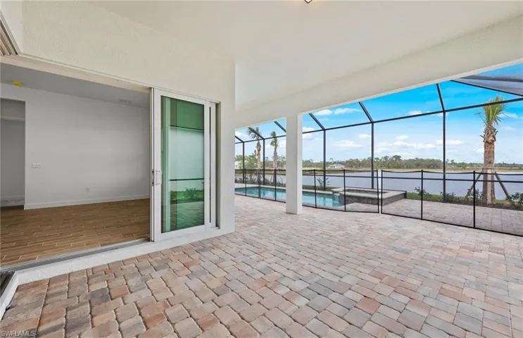 View of patio with a water view and glass enclosure