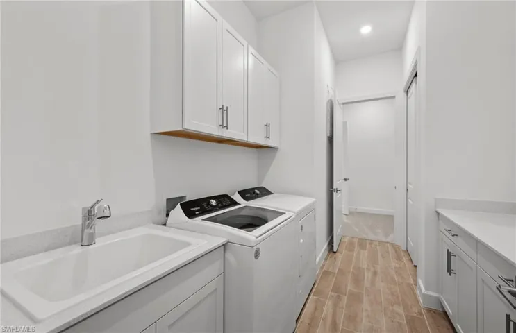 Laundry room featuring cabinets, sink, and washer and dryer