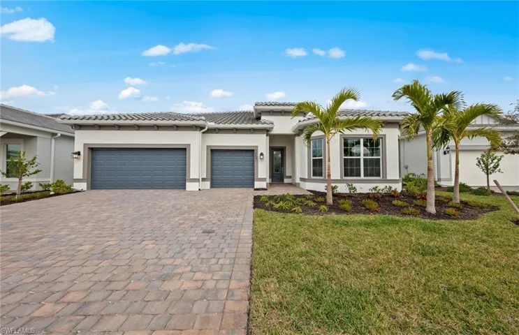 Mediterranean / spanish house with a garage and a front lawn