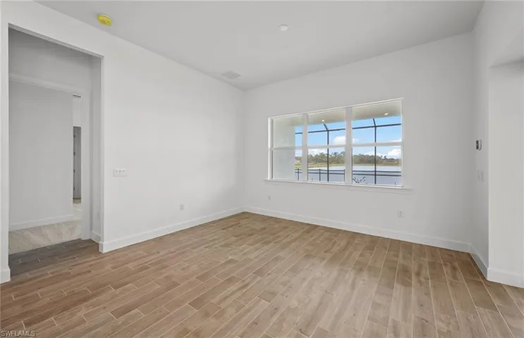 Empty room with a water view and light wood-type flooring