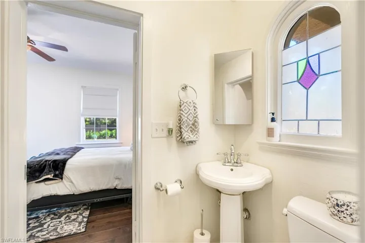 Bathroom with hardwood / wood-style floors, ceiling fan, and toilet