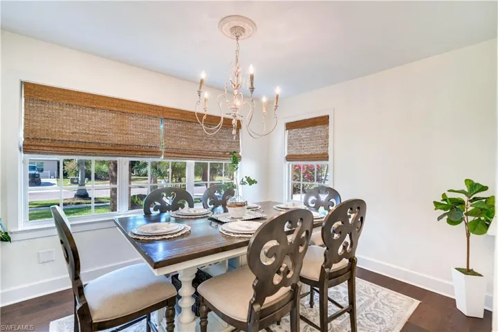Dining area featuring a notable chandelier and dark wood-type flooring