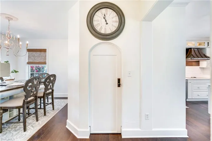 Hallway featuring dark hardwood / wood-style floors and a notable chandelier