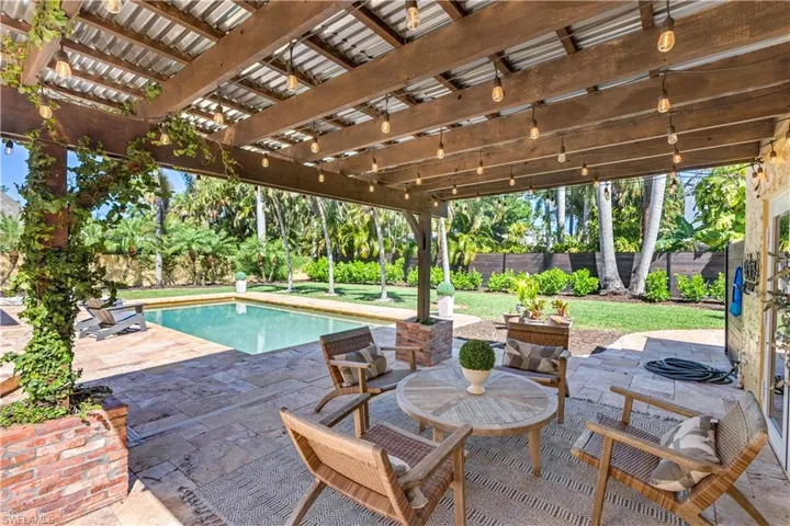View of pool with a patio area and a pergola