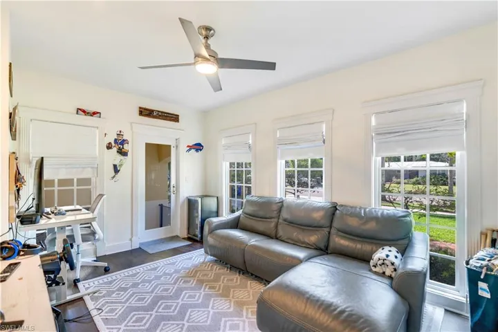Living room featuring a wealth of natural light, dark hardwood / wood-style floors, and ceiling fan