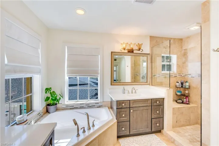 Bathroom featuring plus walk in shower, plenty of natural light, and vanity