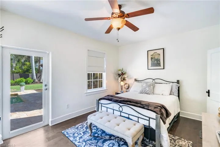 Bedroom featuring dark hardwood / wood-style floors, ceiling fan, and access to exterior
