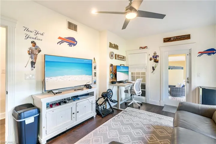Living room featuring ceiling fan and dark hardwood / wood-style floors