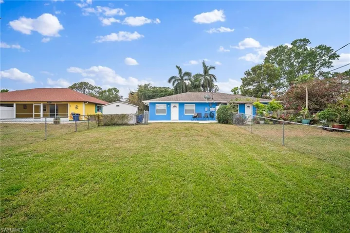 Rear view of house featuring a yard