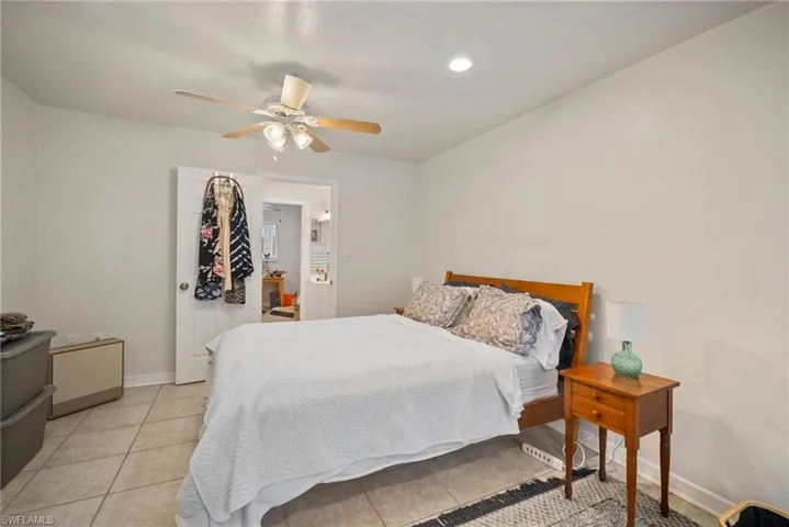 Tiled bedroom featuring ceiling fan