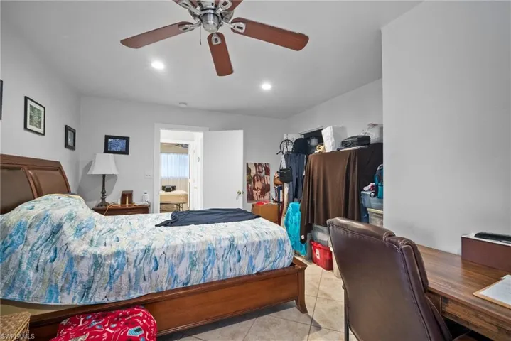 Bedroom with ceiling fan and light tile patterned floors